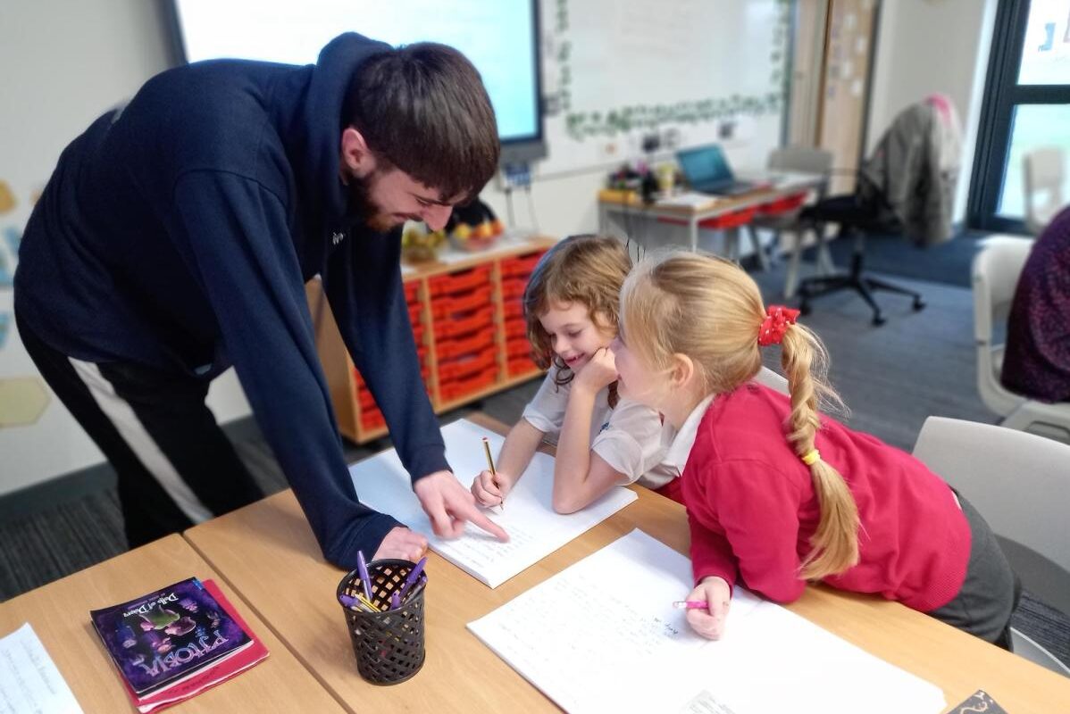 newly qualified teacher working with two pupils